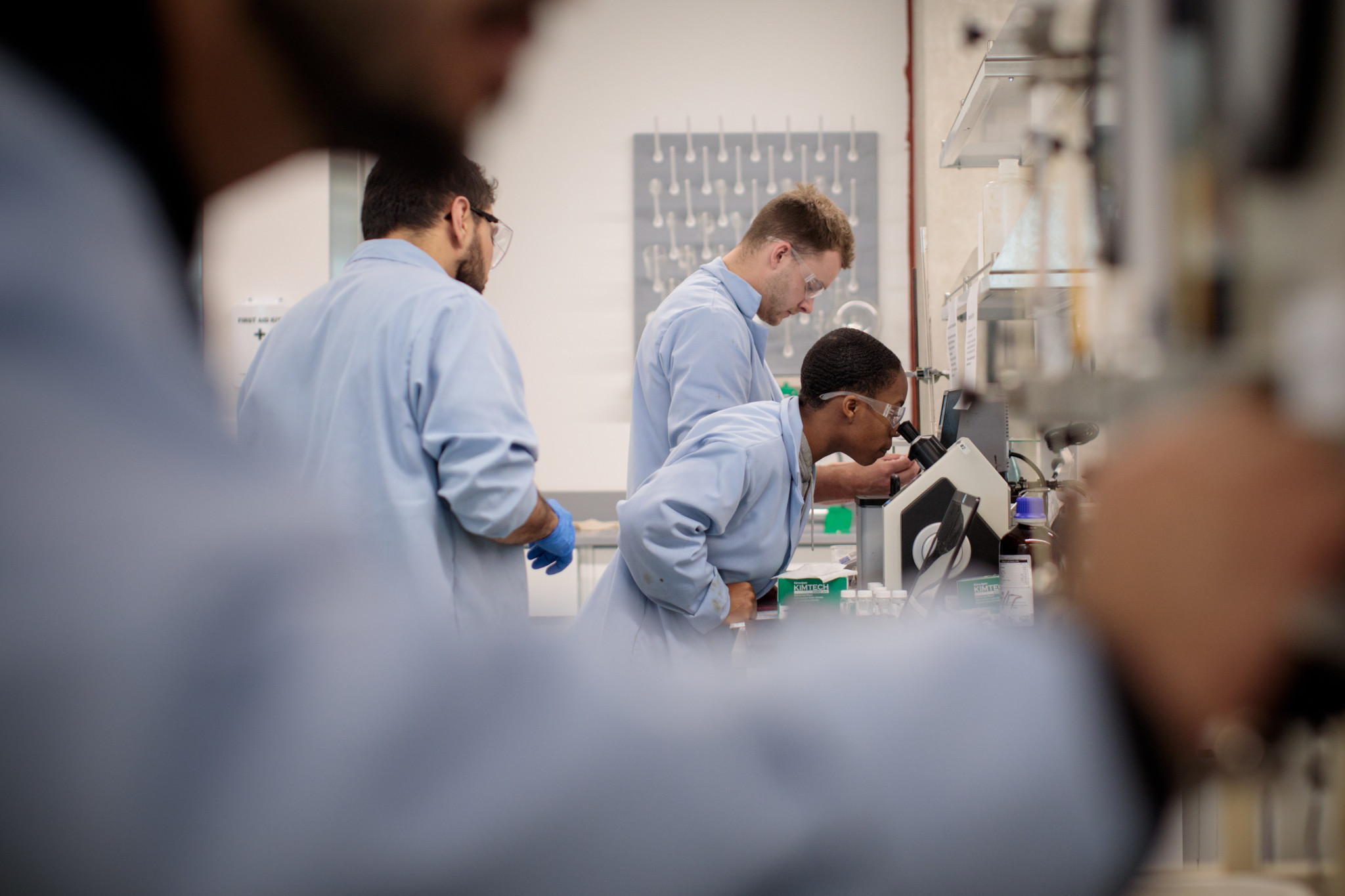 Petroleum engineering students looking into microscope